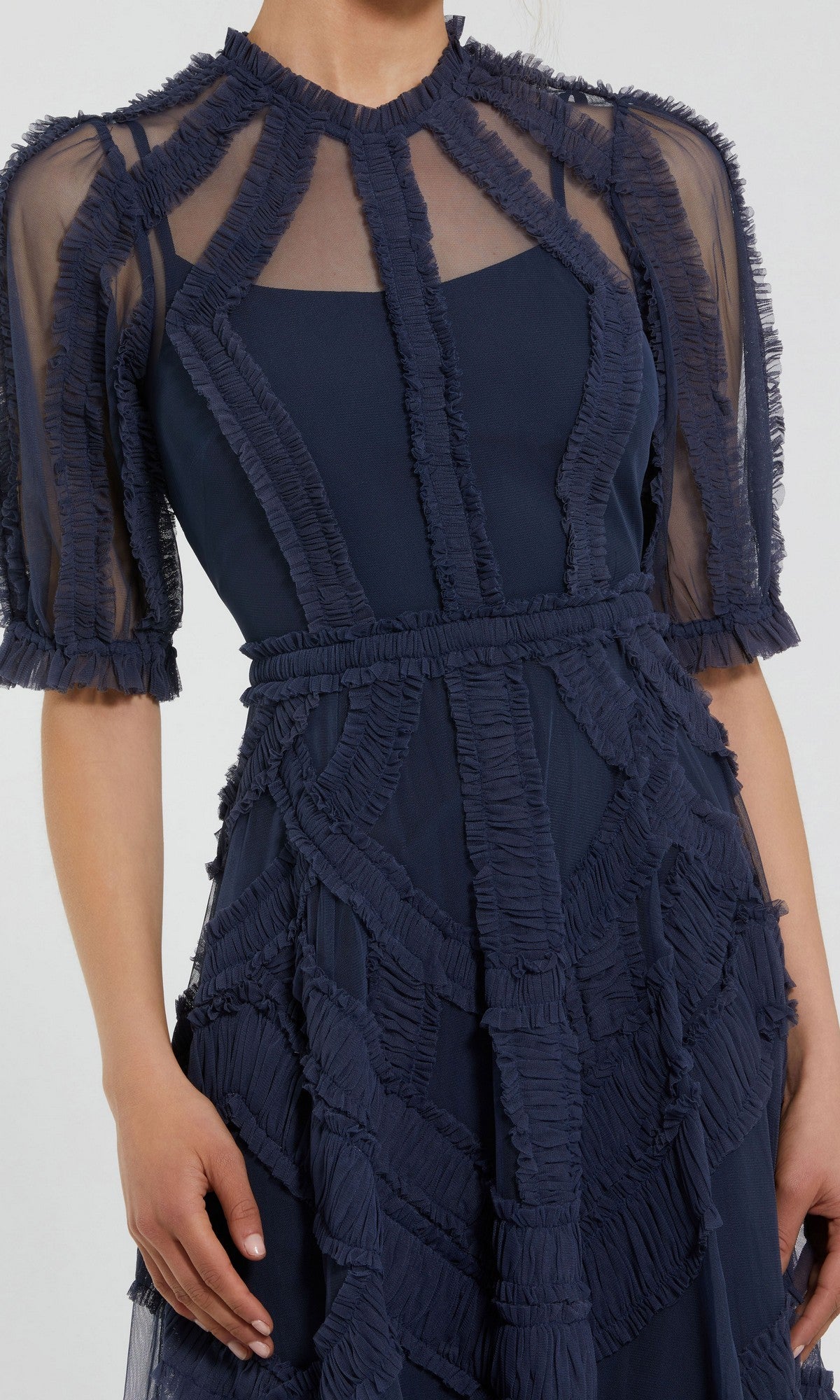 A woman wearing the Mac Duggal 8058 Ruffled Midi Wedding-Guest Dress in navy blue, featuring sheer short sleeves and decorative ruffled geometric trim on the bodice and skirt.